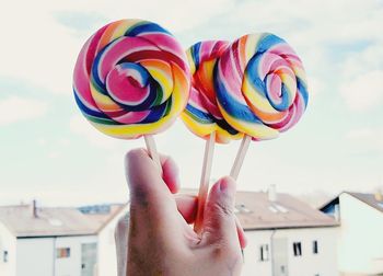 Close-up of hand holding multi colored umbrella