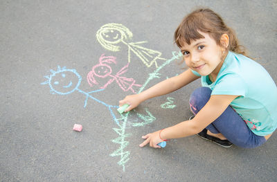 High angle view of girl drawing on road