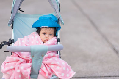 Portrait of cute girl sitting in baby stroller