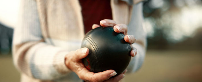 Midsection of woman holding dumbbell