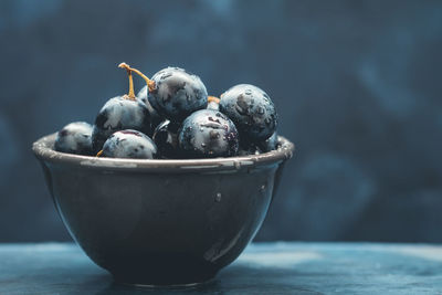 Close-up of wet grapes in bowl on table