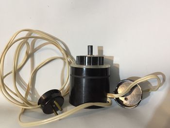 Close-up of electric lamp on table against white background