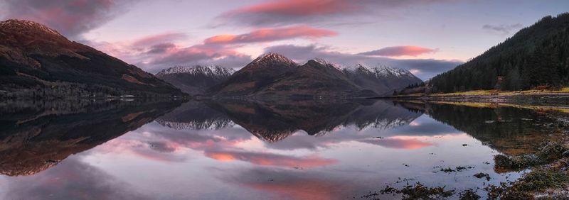 Scenic view of lake and mountains against sky during sunset