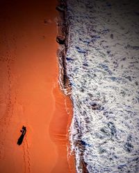 Aerial view of man at beach during sunset