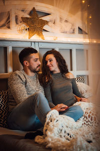 Young couple sitting in corridor