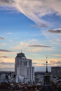 Buildings in city against cloudy sky