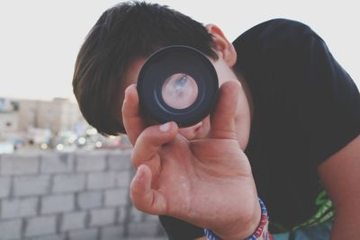 Portrait of boy looking through camera lens