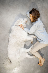 High angle view of woman by cat on floor