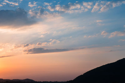 Low angle view of silhouette mountain against dramatic sky