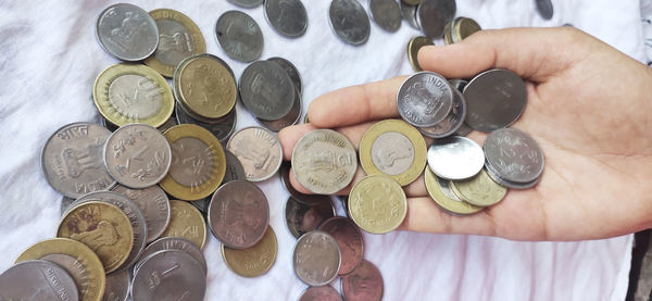 High angle view of hand holding coins