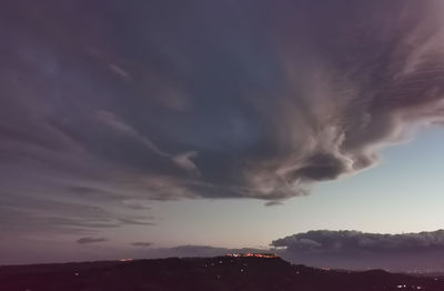 Low angle view of storm clouds over mountain