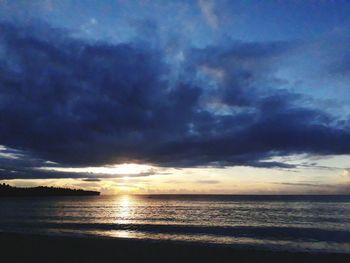 Scenic view of sea against dramatic sky during sunset