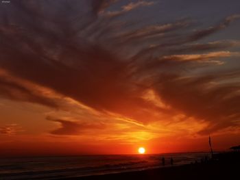 Scenic view of sea against dramatic sky during sunset