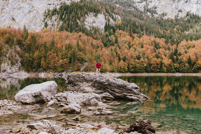 Man standing on rock by lake