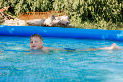 Portrait of smiling boy swimming in pool