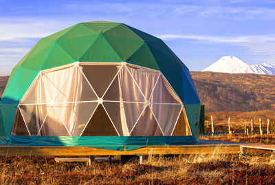 Green geo-dome tent on kamchatka peninsula. cozy, camping, glamping,  lifestyle concept. 