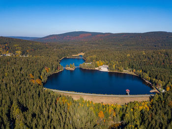 Scenic view of lake and mountains against clear blue sky