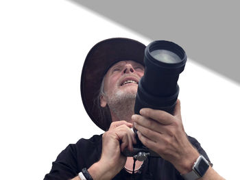 Low angle view of man wearing hat against white background