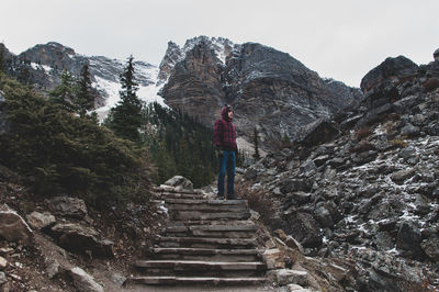 Hiker standing on staircase against mountains