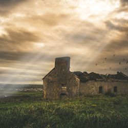 Old building on field against sky