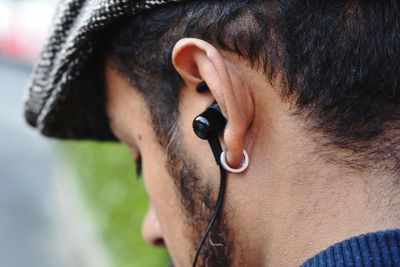 Close-up of man listening music through headphones