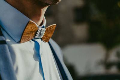 Close-up midsection of man wearing wooden bow tie
