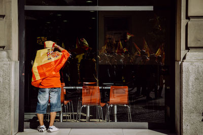 Man looking through cafe window with reflection during protest