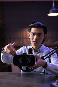 Young man using mobile phone while sitting on table