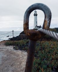 Close-up of rusty metal railing against sky