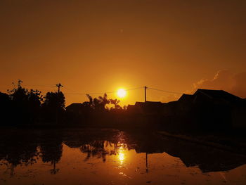 Scenic view of lake against orange sky