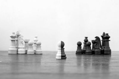 Close-up of chess pieces on table against white background