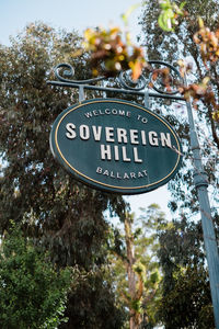 Low angle view of road sign against trees