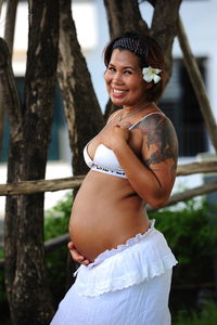 Portrait of happy pregnant woman standing outdoors