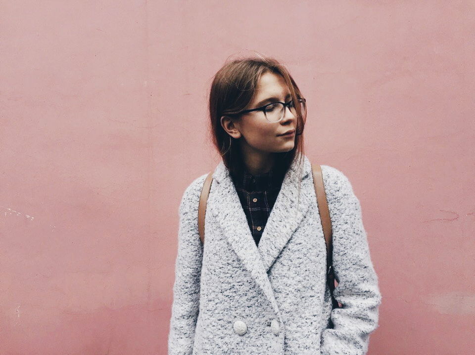 PORTRAIT OF HAPPY WOMAN STANDING AGAINST WALL