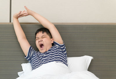 Low angle view of boy relaxing on bed