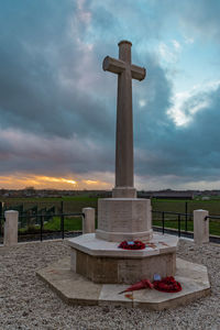 Cross on cemetery against sky during sunset