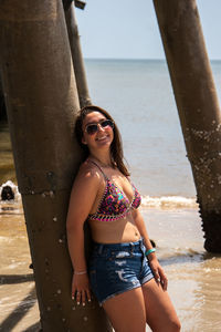 Woman standing against pier at beach