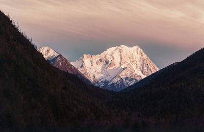 Scenic view of snowcapped mountains against sky during sunset