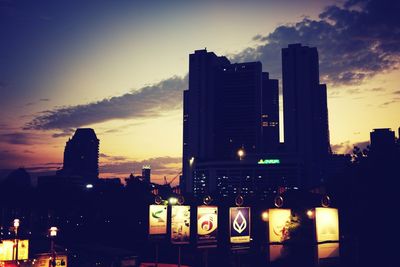 Illuminated cityscape against sky at dusk