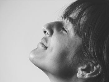 Close-up of woman with closed eyes by gray background