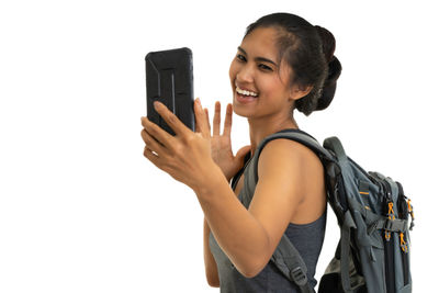 Smiling young woman using smart phone against white background