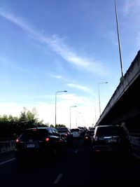 Cars on road in city against sky