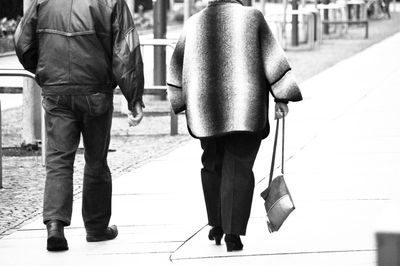 Low section of people walking on sidewalk