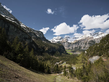 Beautiful alpine view of high snow capped mountains, pine forest trees and mountainous landscape. 