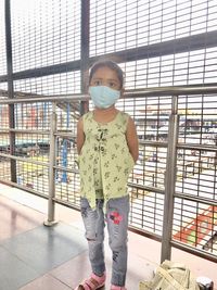 Portrait of girl standing against window