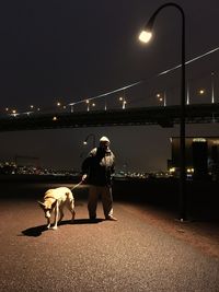 Senior man with dog on street at night