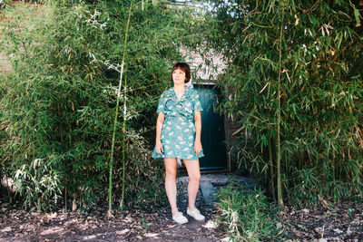 Full length of woman standing against trees