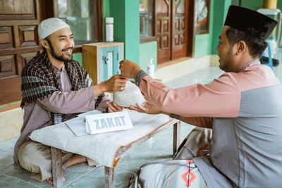 Man helping with rice bag at mosque