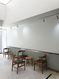 Empty chairs and table against wall at home