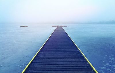 Pier over sea against sky during winter